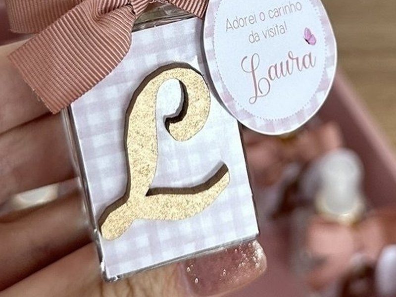 R�tulo xadrez vichy ros� com a letra L aplicada em relevo dourado com textura de glitter, sobre o vidro do frasco