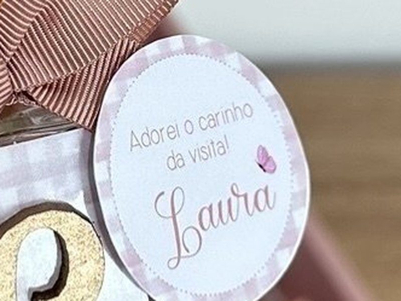 Tag redonda com borda serrilhada, borboleta e o texto Adorei o carinho da visita sobre o nome Laura