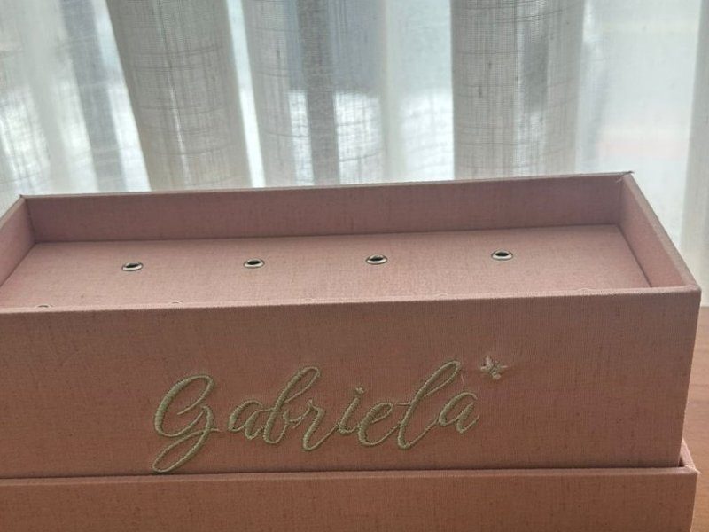 A fileira dupla de ilhoses de metal aberta na tampa da caixa, por onde passam as hastes dos pirulitos