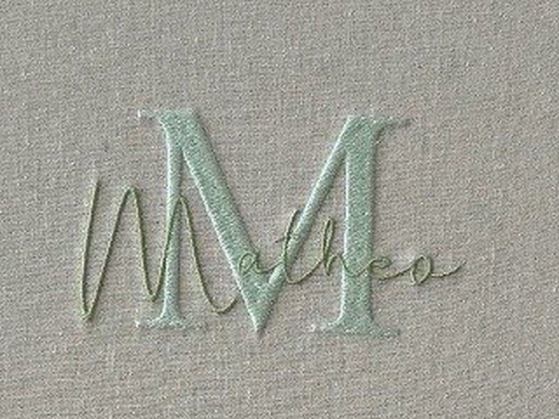 O monograma da tampa: um M grande em verde-claro com Mateo escrito por cima em cursiva, formando uma �nica composi��o