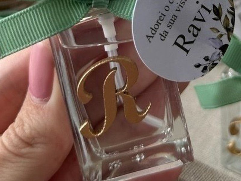 O frasco do home spray com a inicial R aplicada em dourado na frente e a v�lvula dourada