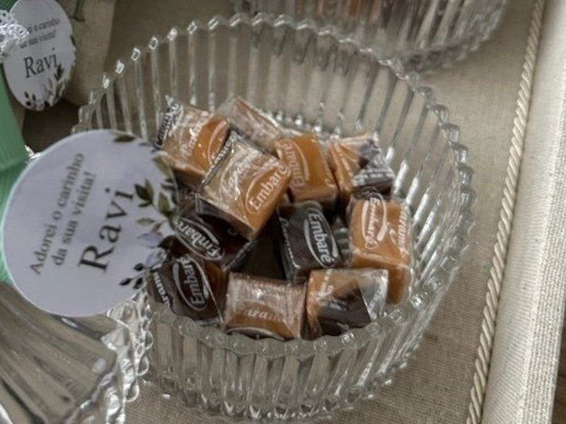 O baleiro de vidro canelado aberto, com as balas de caramelo dentro