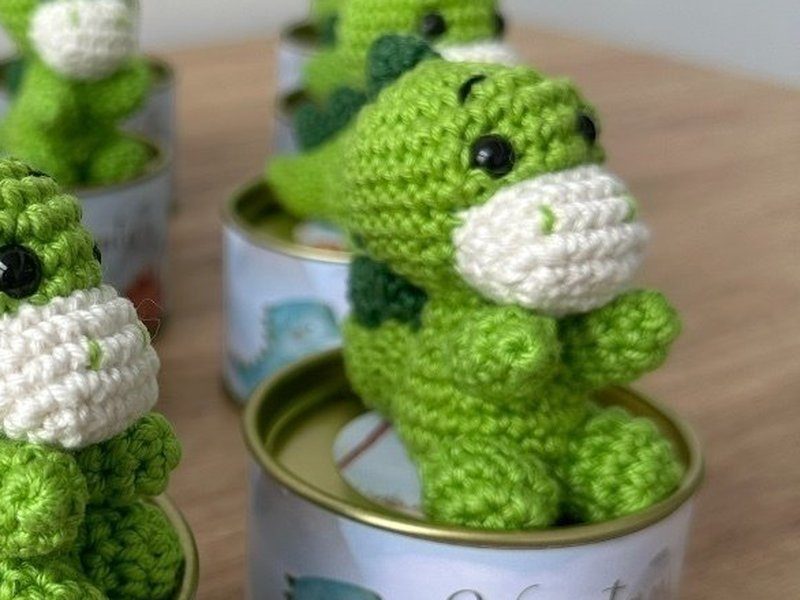 O dinossauro em close: o ponto do croch�, o focinho cru, a crista verde-escura e os olhos pretos aplicados