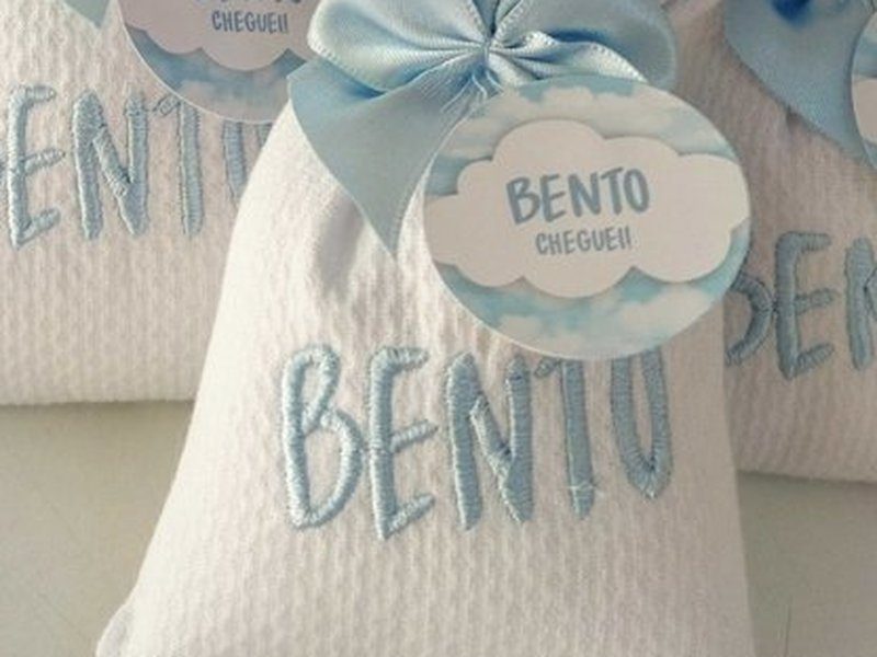 Sach� em tecido piquet branco com BENTO bordado em azul-claro em letra bast�o mai�scula, renda fina e la�o de cetim azul