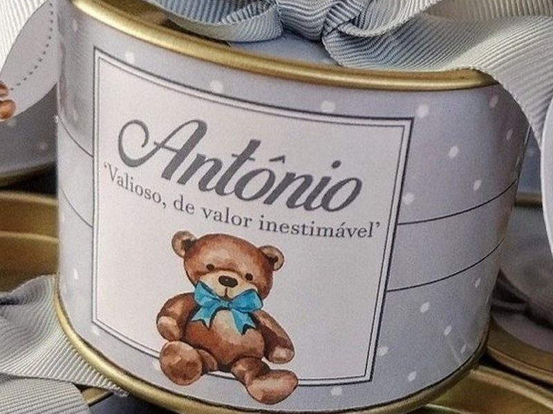 R�tulo cinza de po� com o nome Ant�nio em cursiva, a frase 'Valioso, de valor inestim�vel' e um ursinho marrom com la�o azul