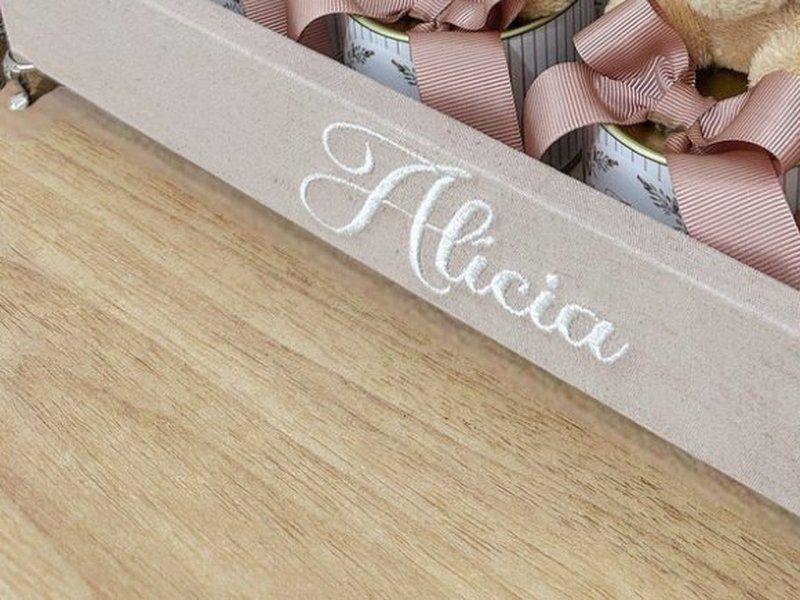 O nome Alicia bordado por inteiro em cursiva branca na lateral da bandeja