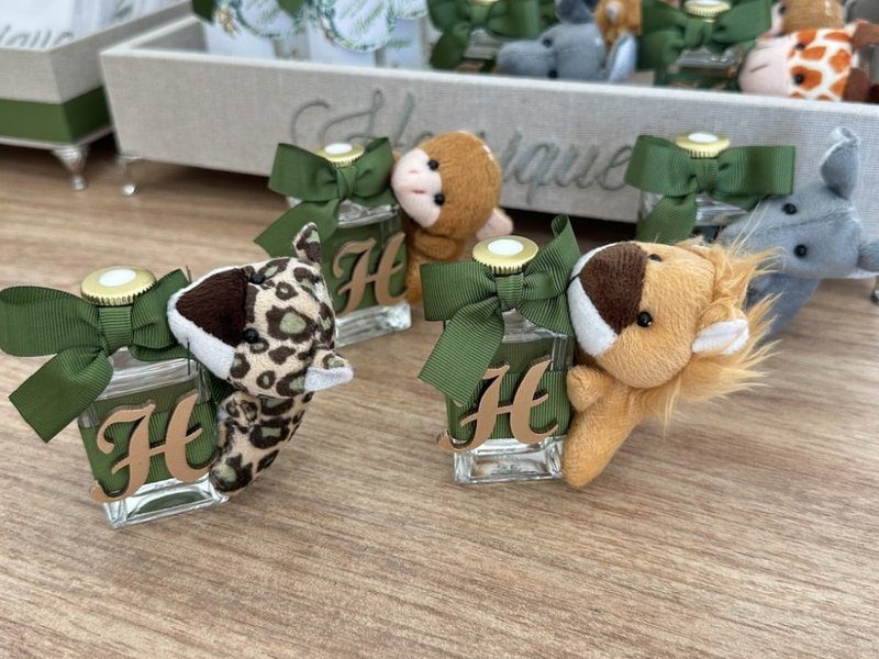 Tr�s frascos iguais com a inicial H dourada, cada um com uma pel�cia diferente: on�a, macaco e le�o