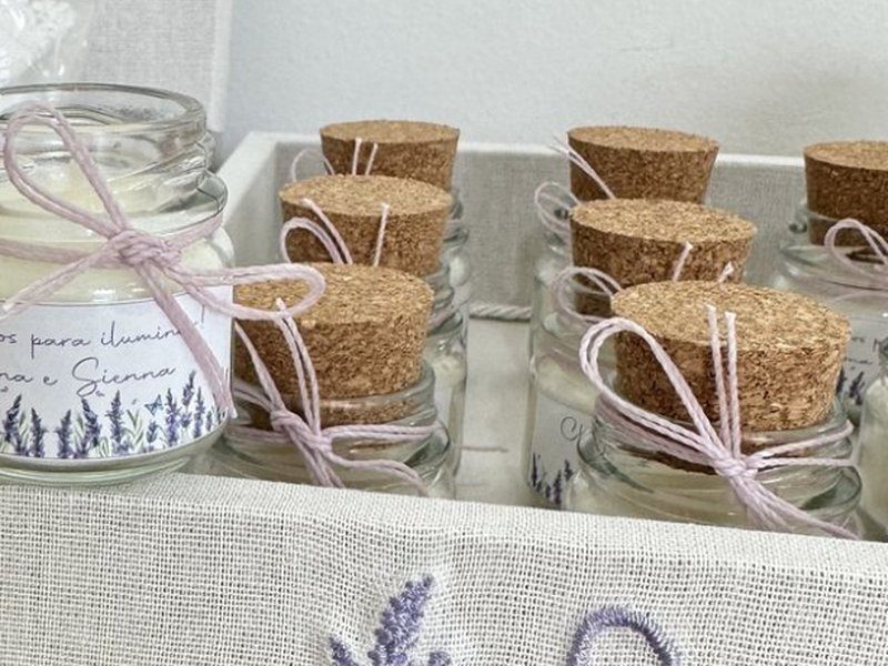 Velas em potinhos de vidro fechados com tampa de rolha e amarrados com cord�o rosa