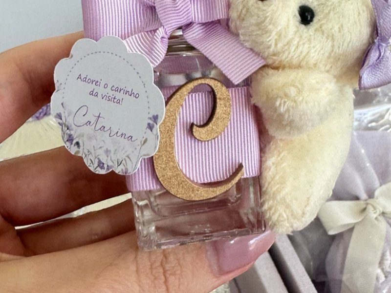 A mesma pe�a com la�o lil�s, lacinho lil�s no urso e letra C dourada