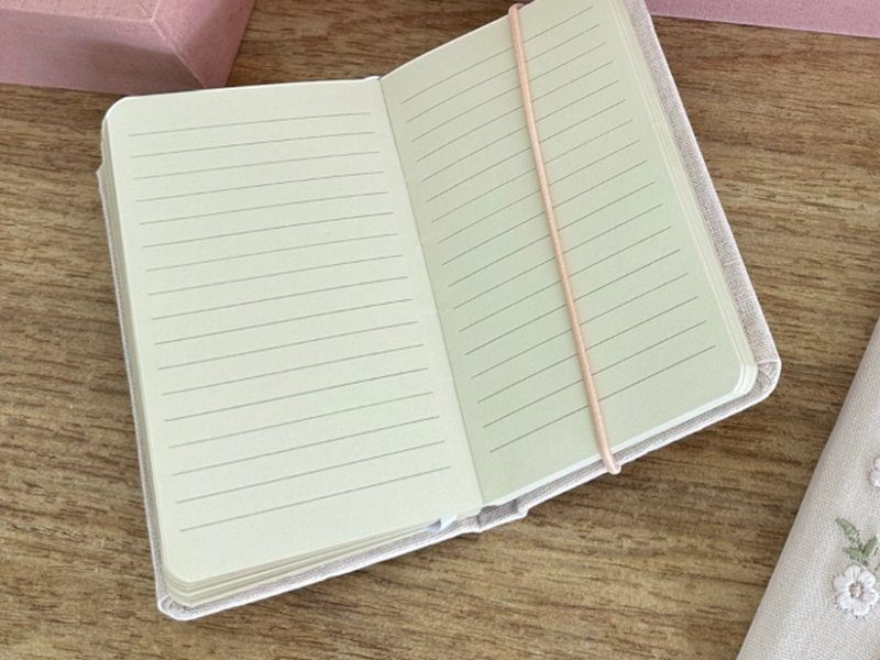 Caderno aberto mostrando o miolo de folhas pautadas creme