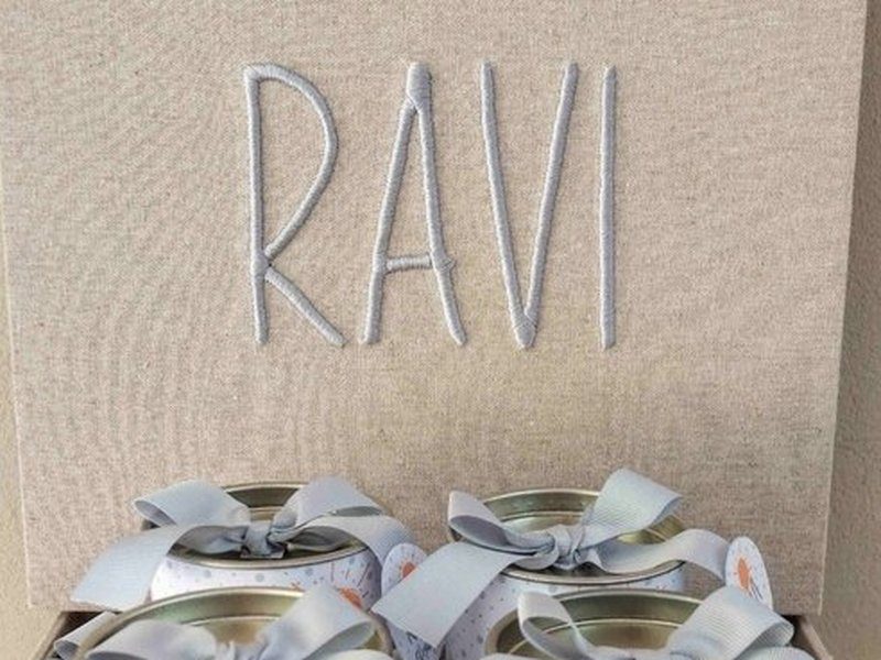 RAVI bordado em azul-claro em letra bast�o mai�scula, por inteiro, no linho cru da tampa