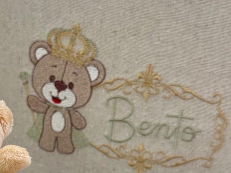 Bordado do urso com coroa, cetro e capa ao lado de moldura dourada com Bento em cursiva verde