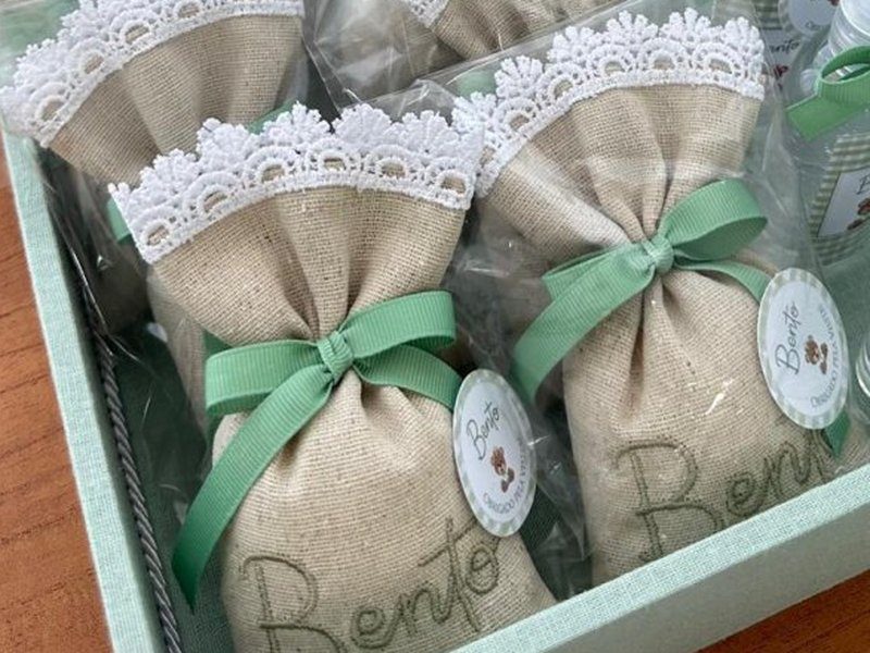Sach� de linho com o nome Bento bordado, acabamento em renda guipir branca e la�o de cetim verde