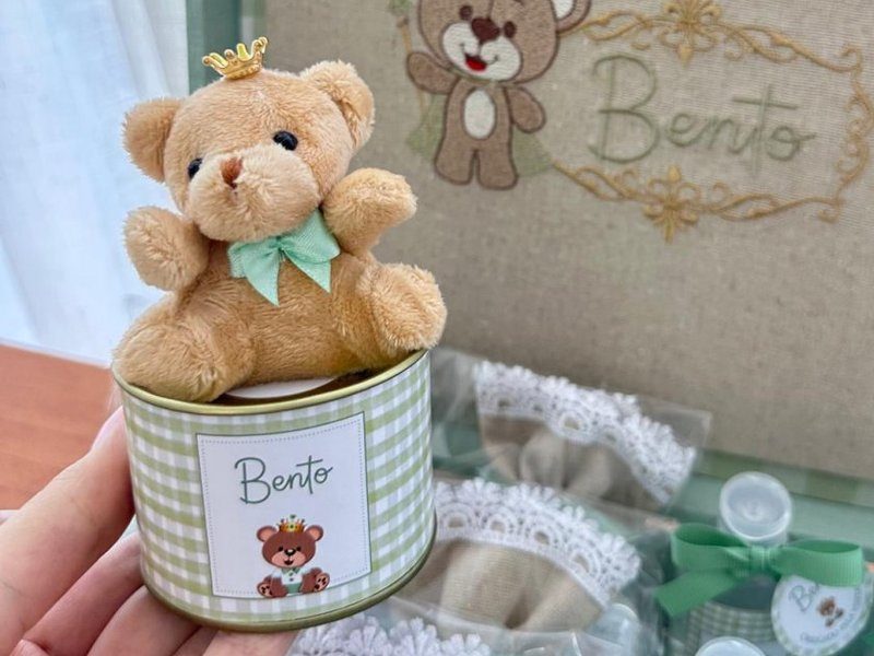 Ursinho de pel�cia com coroa dourada e la�o verde sentado sobre a lata xadrez personalizada