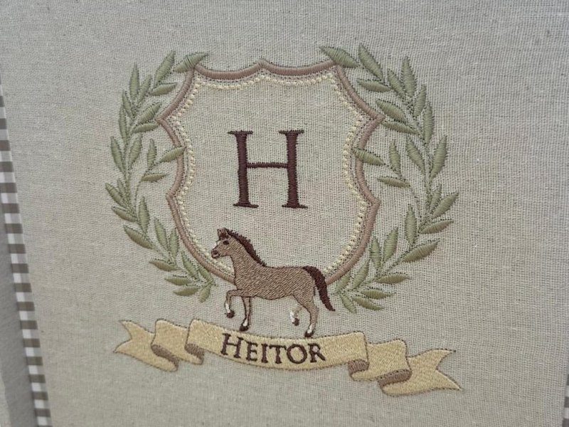 Bras�o bordado com coroa de louros verde, escudo com H, cavalo trotando e faixa com HEITOR