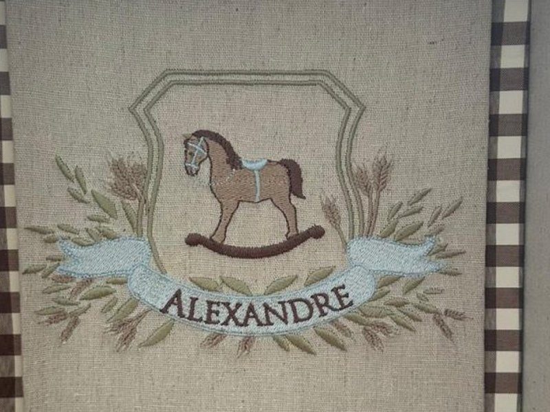 Cavalo de balan�o bordado com sela azul, espigas ao redor e faixa azul com ALEXANDRE