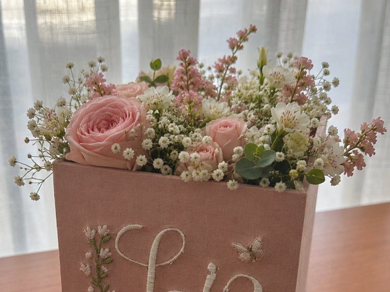 O cachep� servindo de vaso, preenchido com rosas, gipsofila e flores brancas