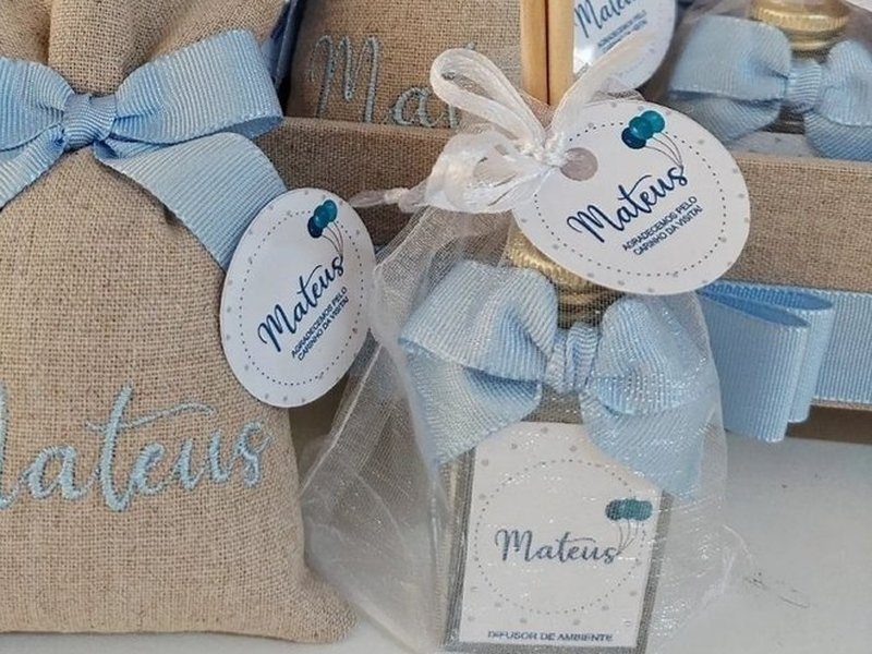 Aromatizador de vidro com tampa dourada dentro de saquinho de organza, com varetas, la�o azul e r�tulo 'Difusor de ambiente'