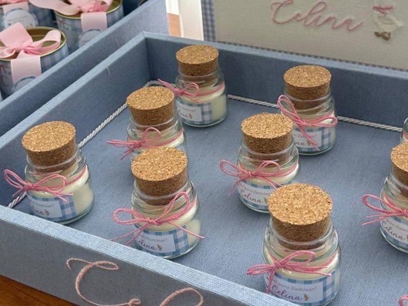 Velas em pote de vidro com tampa de rolha, la�o de cord�o rosa e r�tulo vichy azul, alinhadas na bandeja