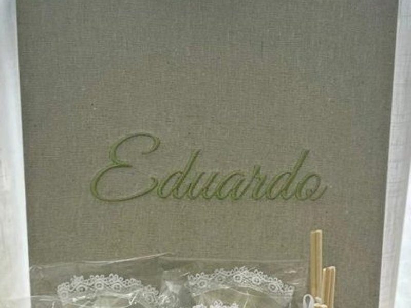 Eduardo bordado em verde em cursiva no linho da tampa levantada