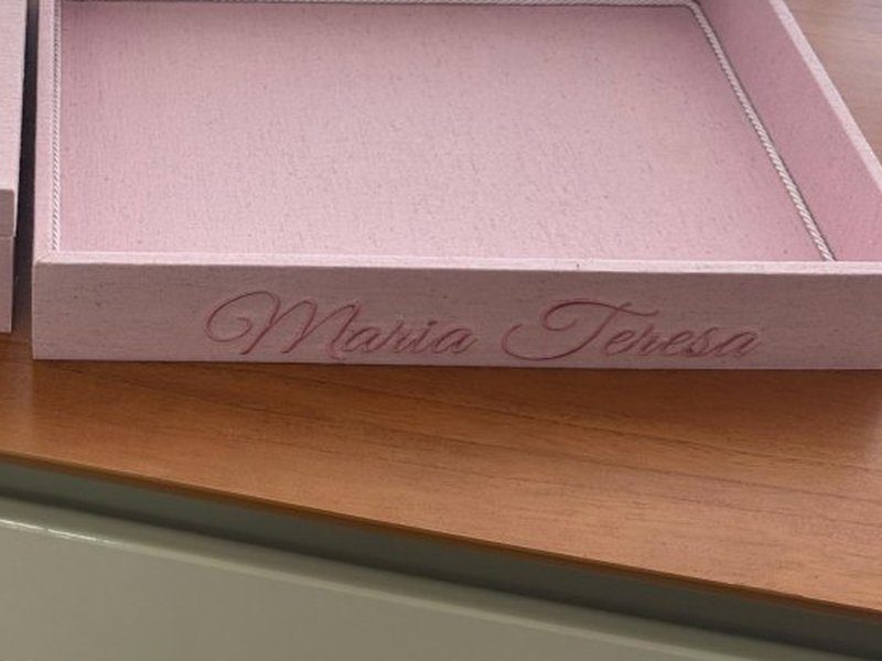 Maria Teresa bordado em cursiva rosa em relevo na lateral frontal da bandeja