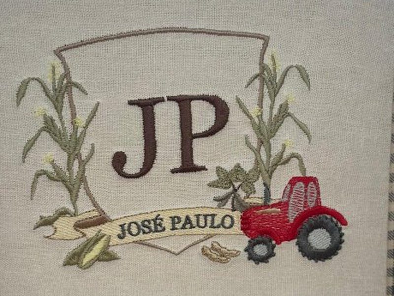Bras�o com as iniciais JP em marrom entre dois p�s de milho, faixa com JOS� PAULO por extenso e um trator vermelho bordado