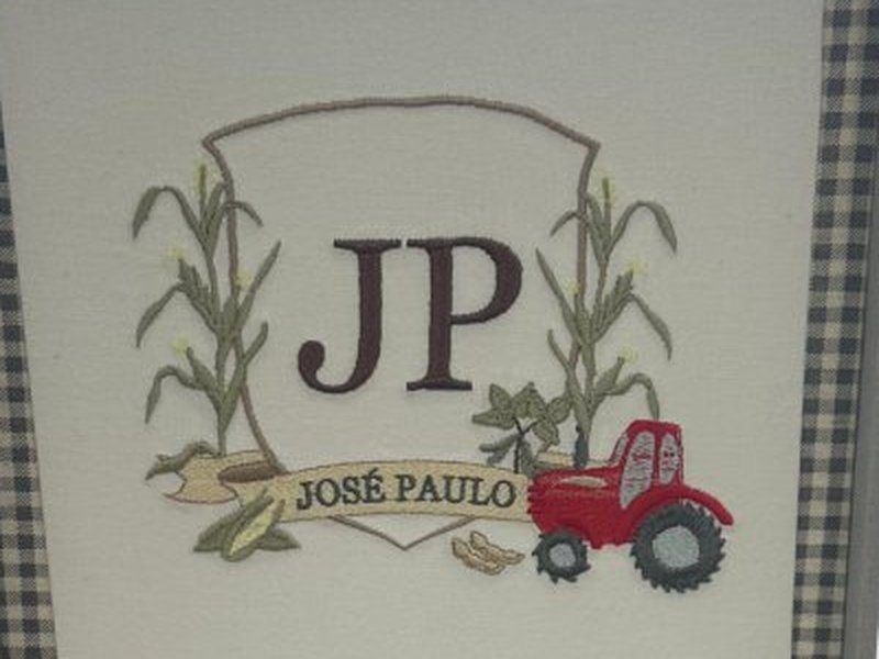 Escudo com monograma JP marrom entre p�s de milho bordados, trator vermelho � direita e faixa com JOS� PAULO
