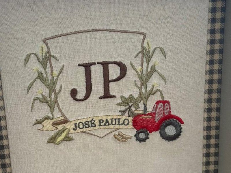 Escudo com JP entre dois p�s de milho, trator vermelho e faixa com JOS� PAULO