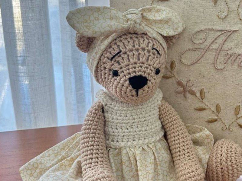 Ursa de croch� com rosto bordado, corpete de croch� cru, saia de tecido floral e turbante de la�o