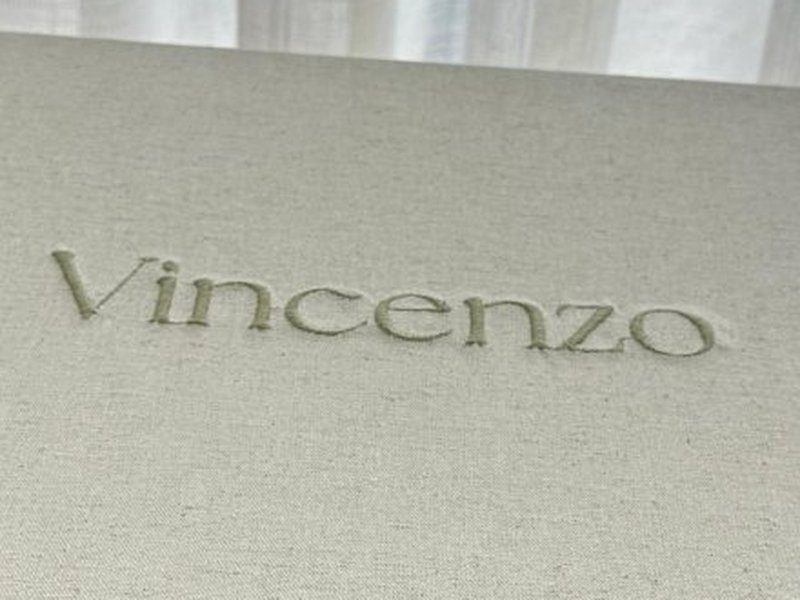 Vincenzo bordado por inteiro em verde sobre o linho cru da tampa fechada