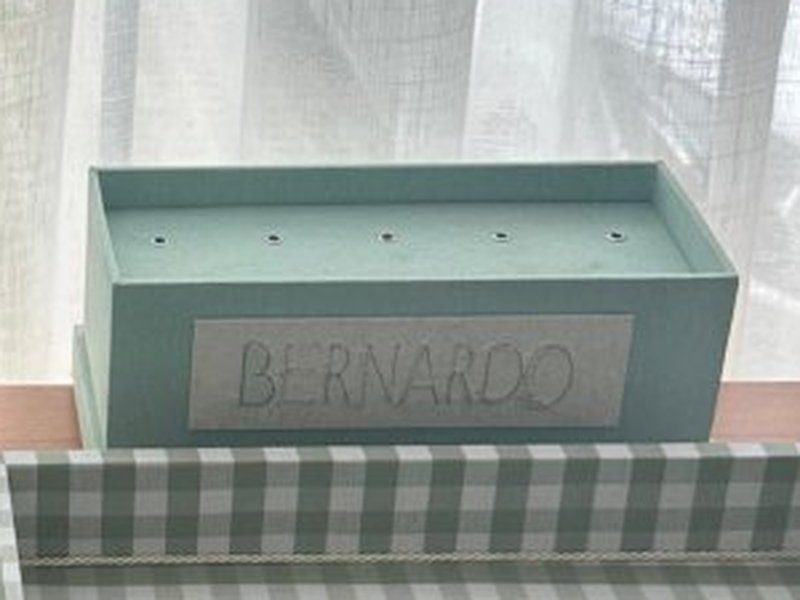 Caixa pirulito verde menta com furos alinhados na tampa e BERNARDO bordado no linho da frente