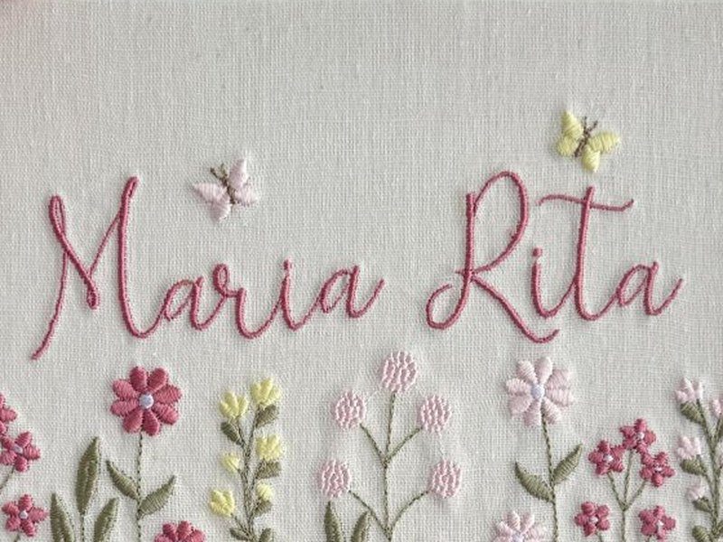 O nome Maria Rita, nome composto, bordado por inteiro em cursiva rosa-escuro numa �nica linha