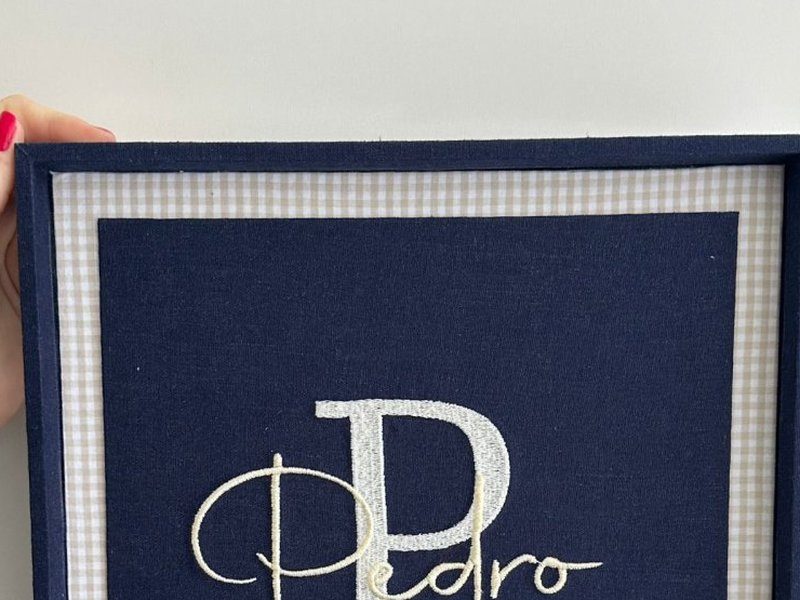 Friso de xadrez bege claro entre o tecido azul escuro da placa e a moldura azul escuro da caixa