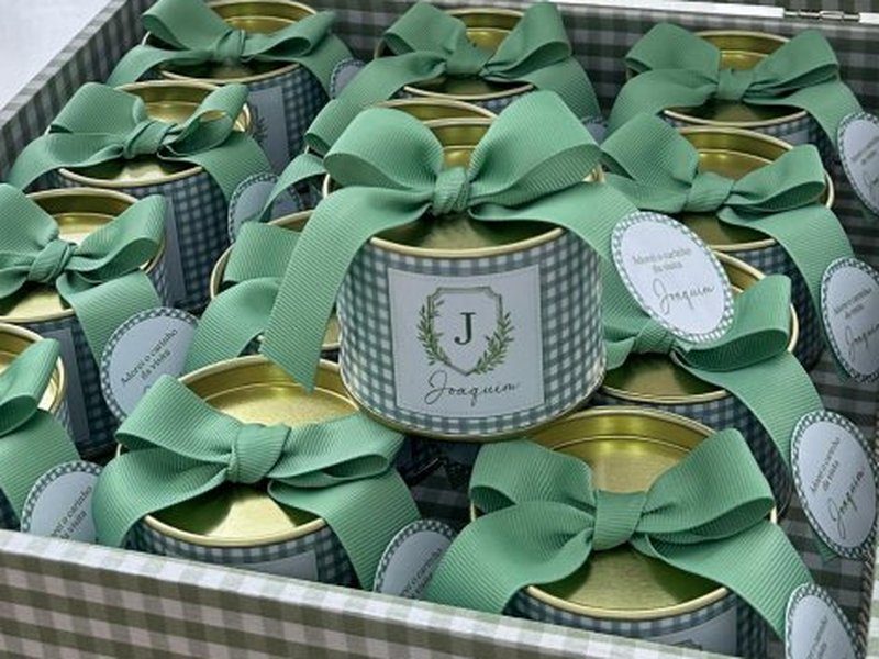 Latas alinhadas com la�o de gorgur�o verde e tag oval com o nome, preenchendo a caixa