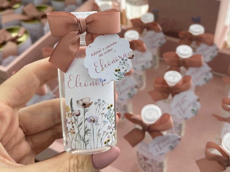 Garrafa de vidro com r�tulo floral trazendo Eleonora, la�o ros� e tag Adorei o carinho da visita