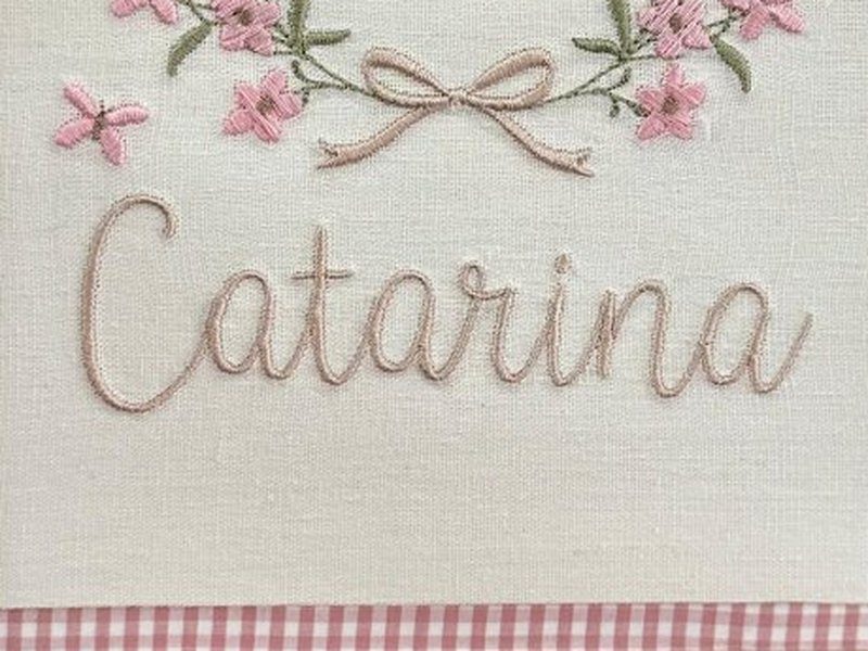 O nome Catarina bordado por inteiro em cursiva bege, do C ao a final