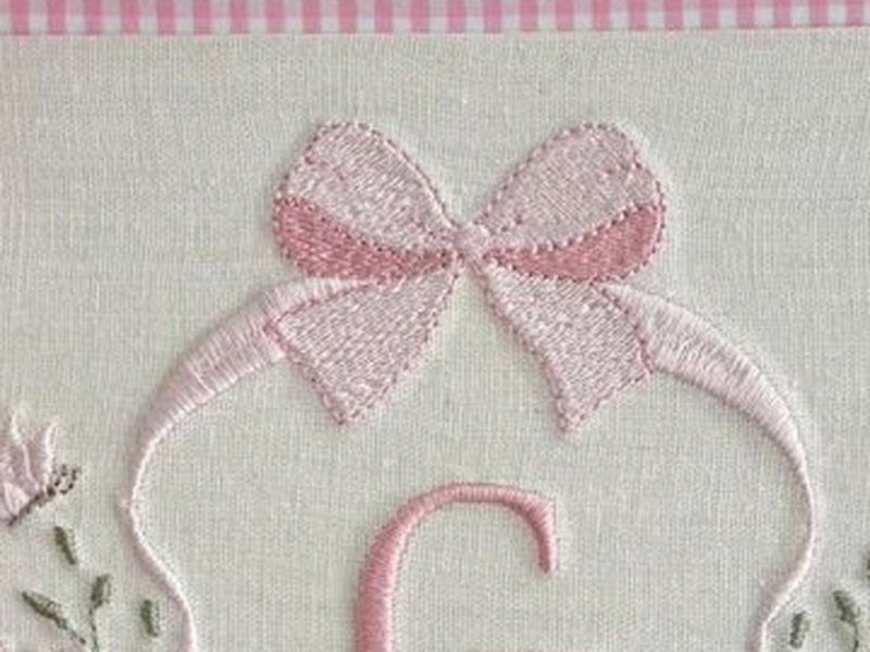 La�o rosa grande em ponto cheio no topo do escudo, com as pontas caindo pelos lados