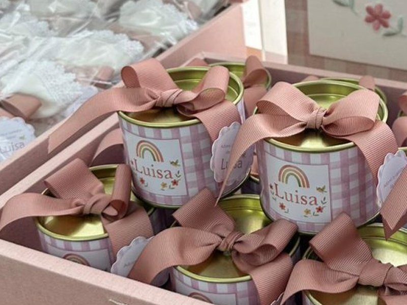 Lata dourada com la�o de gorgur�o rosa-velho e r�tulo xadrez com o arco-�ris e 'Lu�sa'