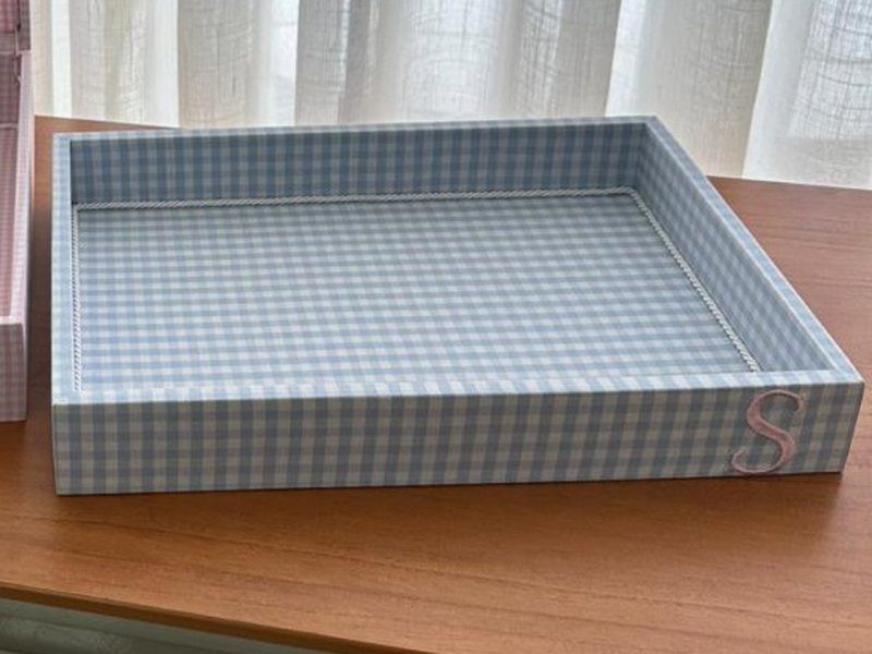 A bandeja em xadrez vichy azul com o 'S' rosa bordado na lateral frontal direita