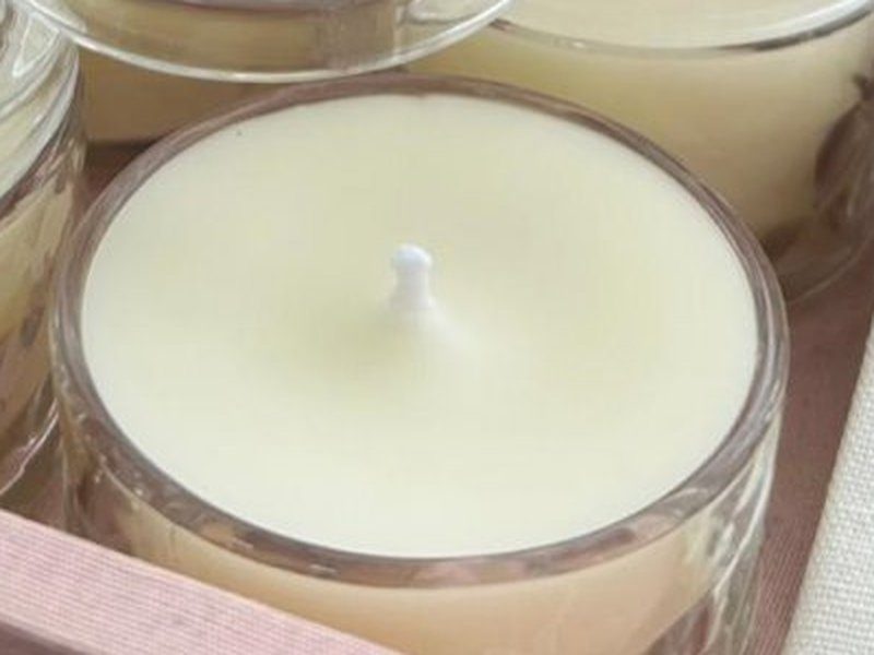 Um pote aberto mostrando o pavio branco no centro da cera creme