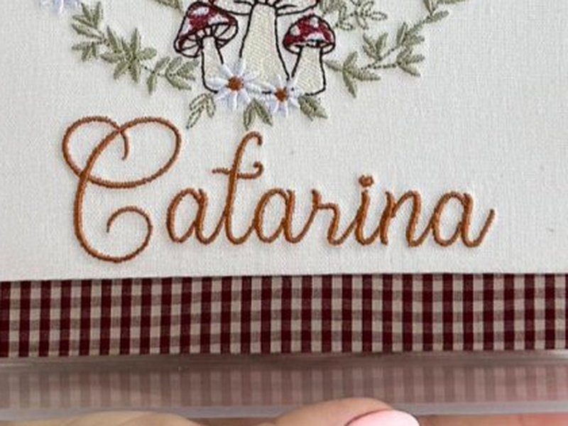 O nome Catarina bordado por inteiro em cursiva cor de caramelo