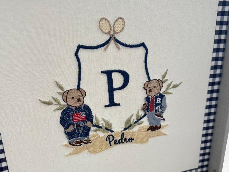 Duas raquetes de t�nis cruzadas sobre o escudo azul escuro, a letra P ao centro, dois ursinhos de palet� nas laterais e a faixa bege com 'Pedro'