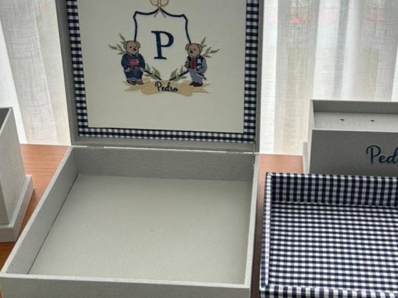 Os dois ursos bordados que ladeiam o bras�o, vestidos de roupa preppy: um de su�ter e cal�a jeans, outro de jaqueta com a letra R