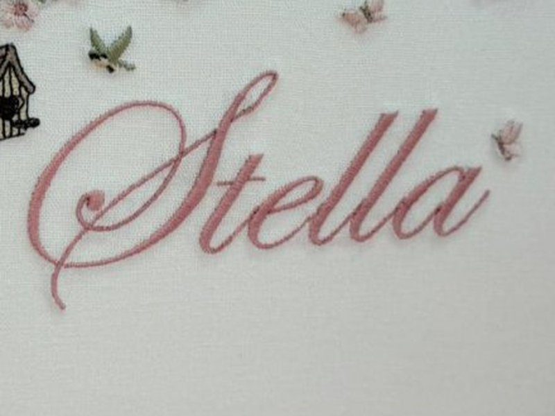 O nome Stella inteiro em cursiva rosa, com a borboleta clara ao lado do a final