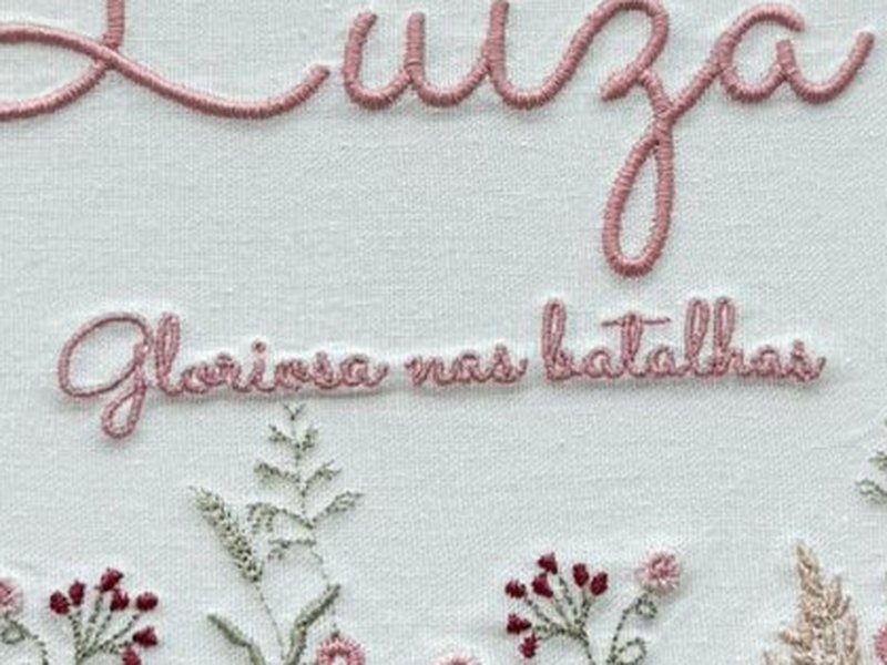 Segunda linha bordada em letra menor com o significado do nome: Gloriosa nas batalhas
