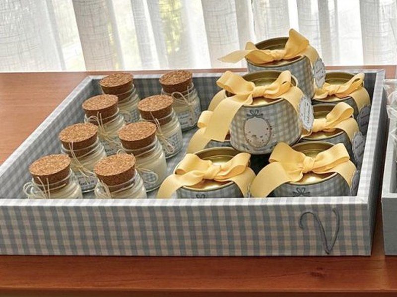 Bandeja xadrez cinza com frascos de rolha alinhados e latas de tampa dourada amarradas com la�o amarelo