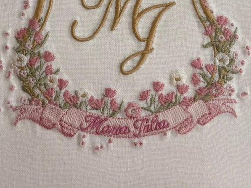 Guirlanda de tulipas rosa e folhas verdes na base do escudo, sobre a faixa com Maria J�lia