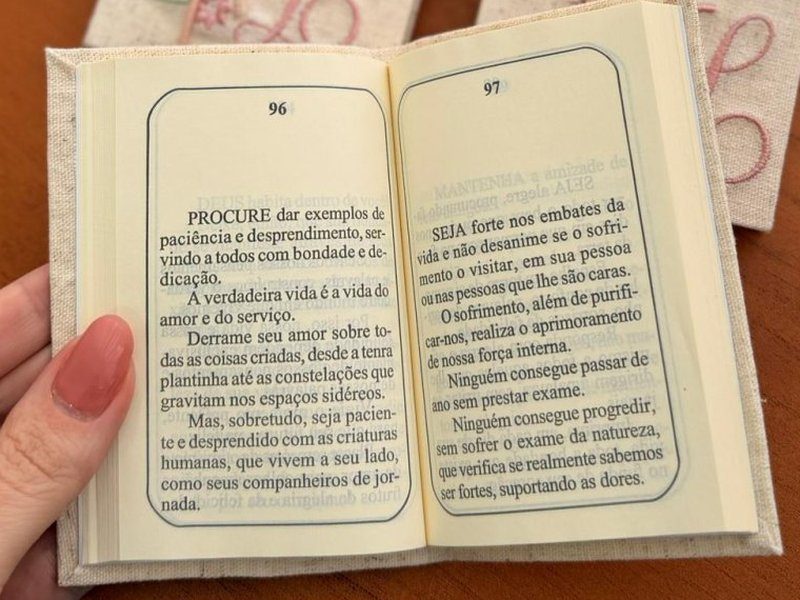 Livrinho aberto nas p�ginas 96 e 97, com par�grafos impressos e numera��o vis�vel
