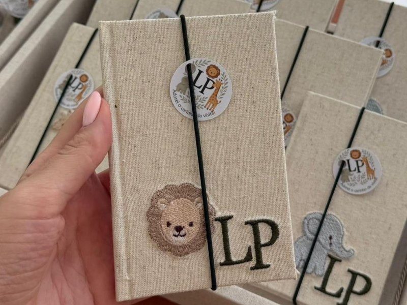 Caderno moleskine de capa de linho com el�stico preto, patch bordado de le�o e as iniciais LP bordadas em verde