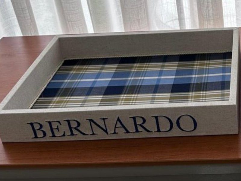 Fundo da bandeja em xadrez tartan azul, verde e branco, com BERNARDO bordado em caixa alta na lateral de linho
